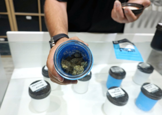 budtender showing open jar of cannabis