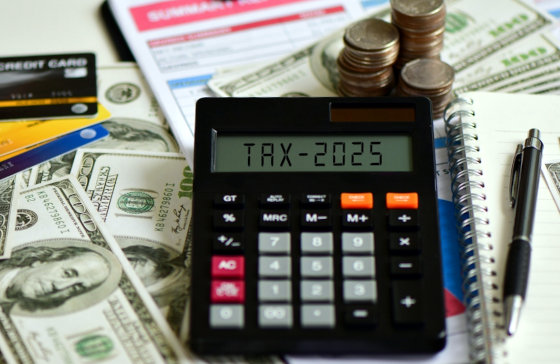 various accounting tools and cash with a calculator reading 2025